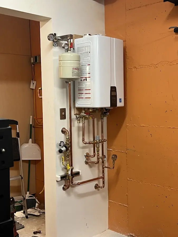 Plumbing technician inspecting water heater connections in Kingsburg